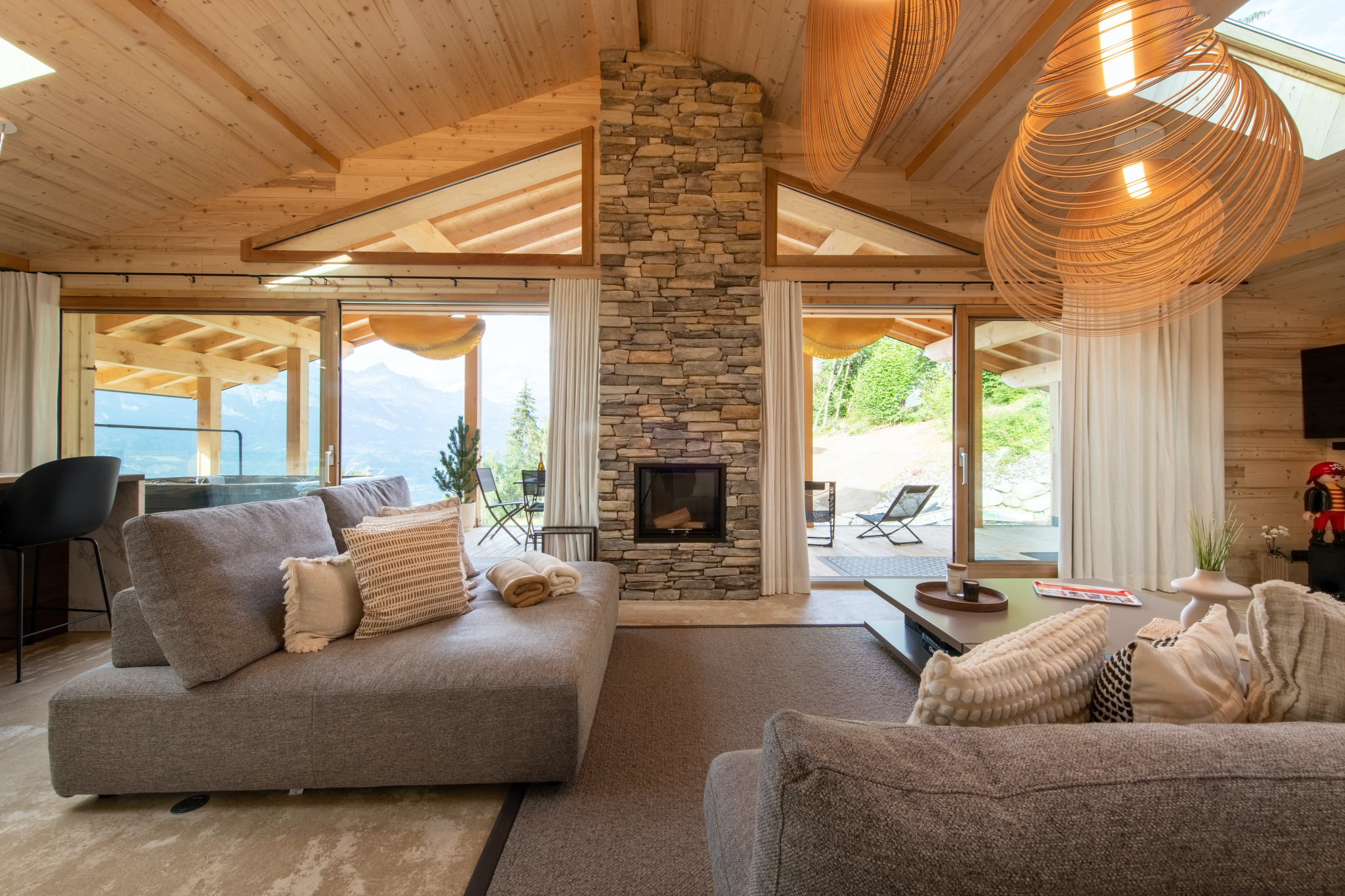 Séjour principal du Chalet Imperial Alpine avec cheminée en pierre et vue montagne